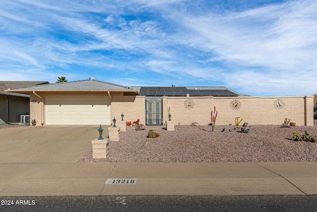 view of front of home featuring solar panels and a garage