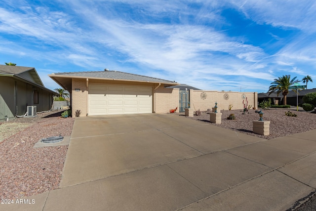 view of front facade with a garage and central AC