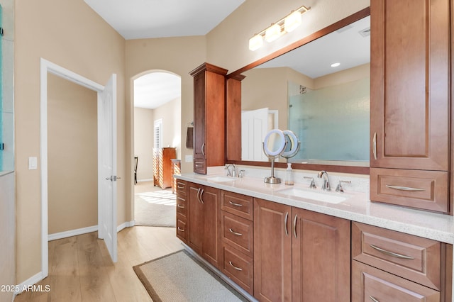 bathroom with an enclosed shower, vanity, and wood-type flooring