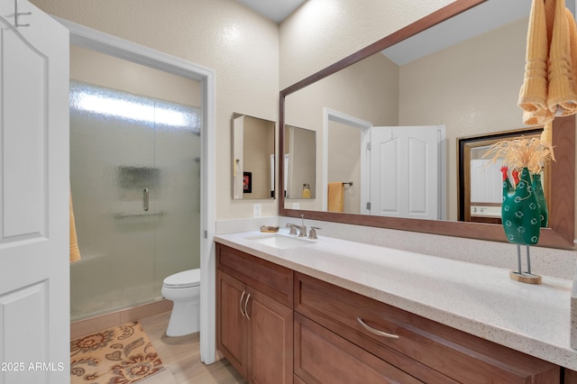 bathroom featuring vanity, toilet, and walk in shower