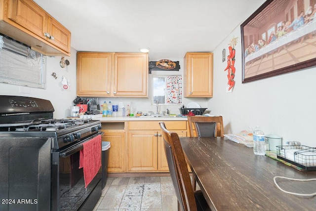 kitchen featuring light brown cabinets, sink, and black range with gas cooktop