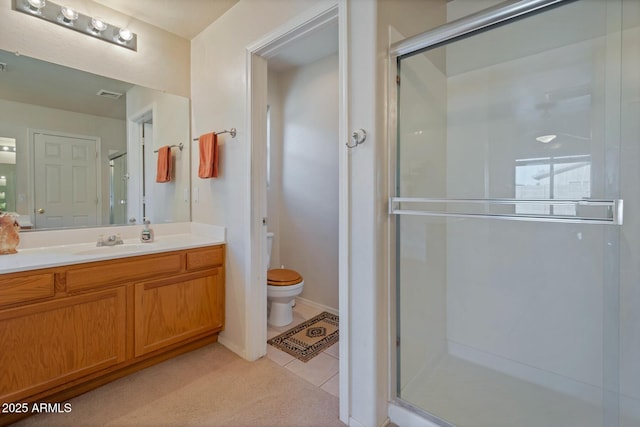 bathroom featuring tile patterned flooring, vanity, toilet, and a shower with shower door