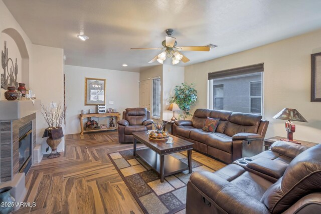 living room with ceiling fan and dark parquet flooring