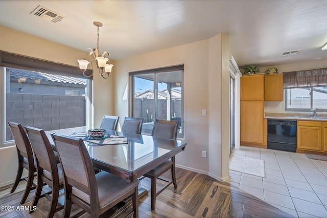 dining room featuring plenty of natural light, light parquet floors, sink, and a chandelier