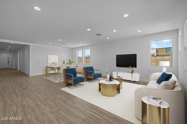 living room featuring recessed lighting, baseboards, visible vents, and wood finished floors
