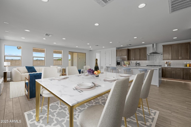 dining area featuring visible vents, recessed lighting, and light wood finished floors