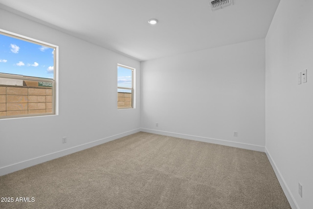 carpeted spare room with recessed lighting, baseboards, and visible vents