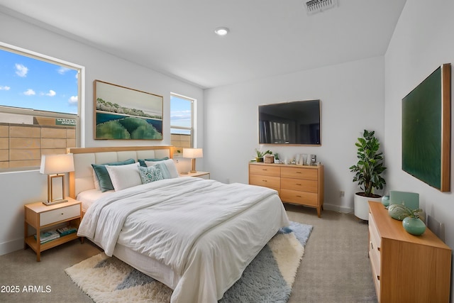 bedroom featuring visible vents, baseboards, and light colored carpet