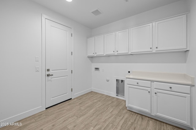 laundry room featuring cabinet space, light wood finished floors, hookup for a washing machine, baseboards, and hookup for an electric dryer