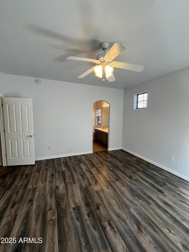 empty room with ceiling fan and dark hardwood / wood-style flooring