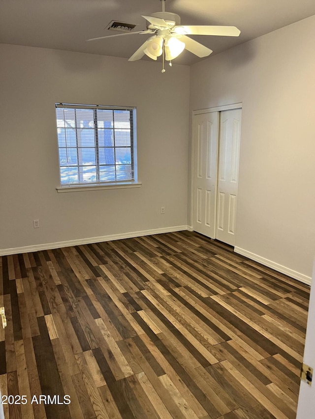 spare room featuring dark hardwood / wood-style floors and ceiling fan