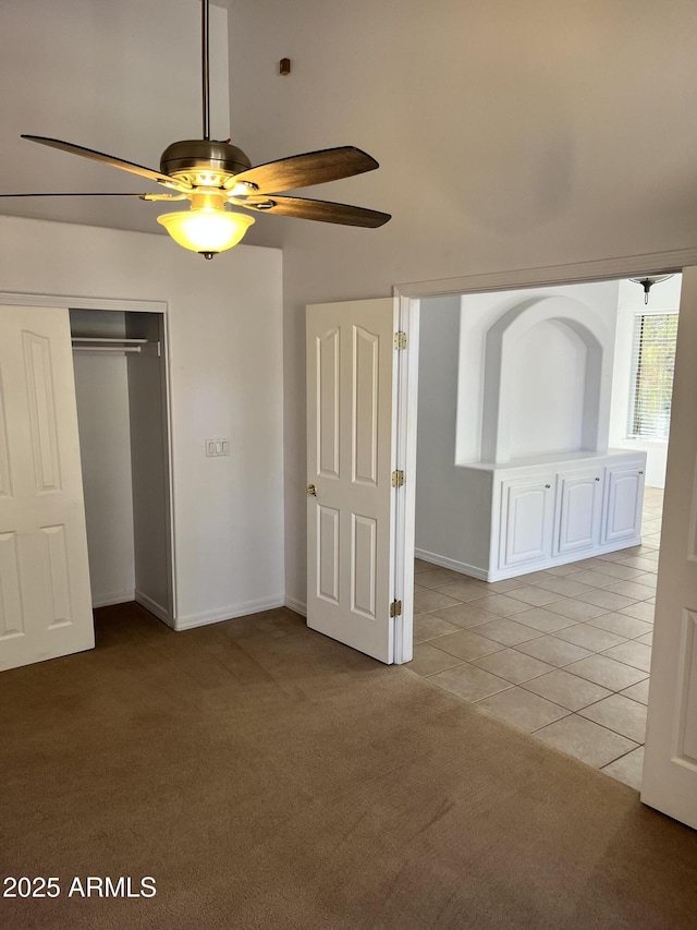 unfurnished bedroom with ceiling fan, light tile patterned flooring, and a closet