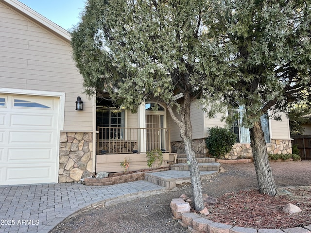 view of exterior entry with covered porch and a garage