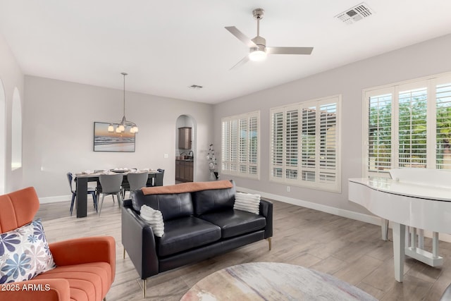 16201 S 29th Ave, Phoenix, AZ 85045 - living room with arched walkways, baseboards, light wood-style flooring, and visible vents