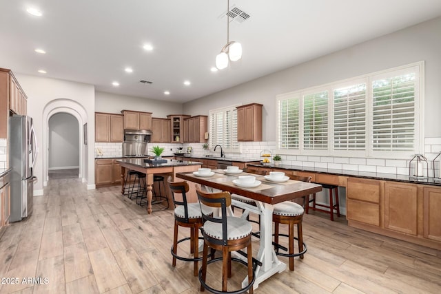 16201 S 29th Ave, Phoenix, AZ 85045 - kitchen featuring dark countertops, appliances with stainless steel finishes, a sink, decorative backsplash, and visible vents