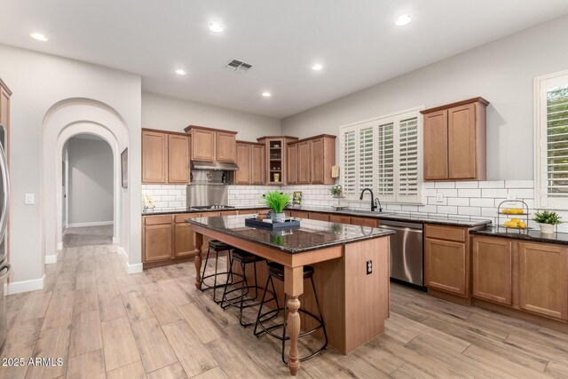 16201 S 29th Ave, Phoenix, AZ 85045 - kitchen with a sink, brown cabinets, a breakfast bar, and stainless steel appliances