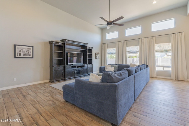 living room with high vaulted ceiling, ceiling fan, and light hardwood / wood-style floors