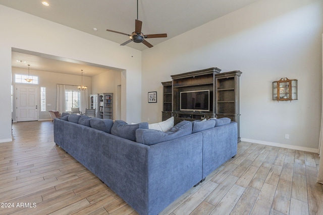 living room featuring light wood-type flooring and ceiling fan with notable chandelier