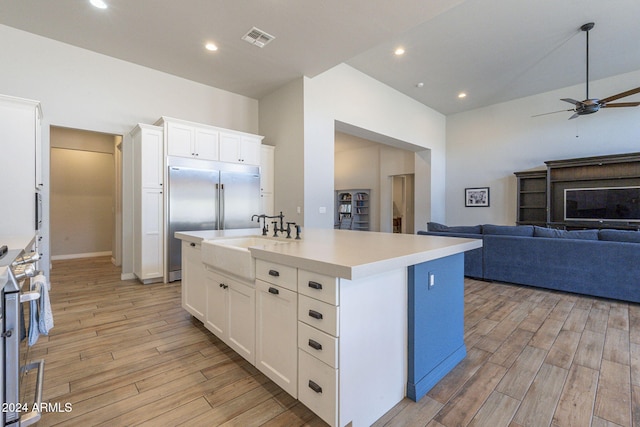 kitchen with white cabinetry, a kitchen island with sink, appliances with stainless steel finishes, and light hardwood / wood-style flooring