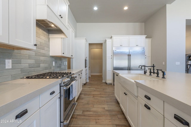 kitchen with white cabinets, light hardwood / wood-style floors, and high end appliances