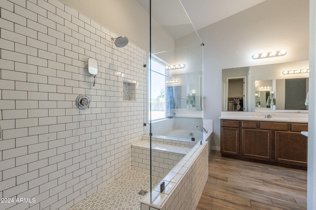 bathroom featuring hardwood / wood-style floors, vanity, plus walk in shower, and lofted ceiling