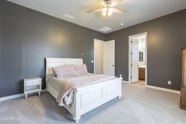 bedroom with light carpet, ceiling fan, and ensuite bath