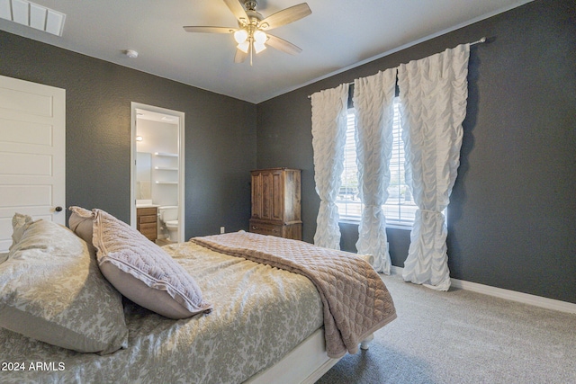 carpeted bedroom featuring ceiling fan, ensuite bath, and a spacious closet