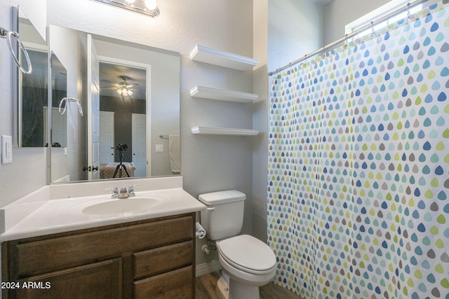 bathroom with toilet, curtained shower, hardwood / wood-style flooring, vanity, and ceiling fan