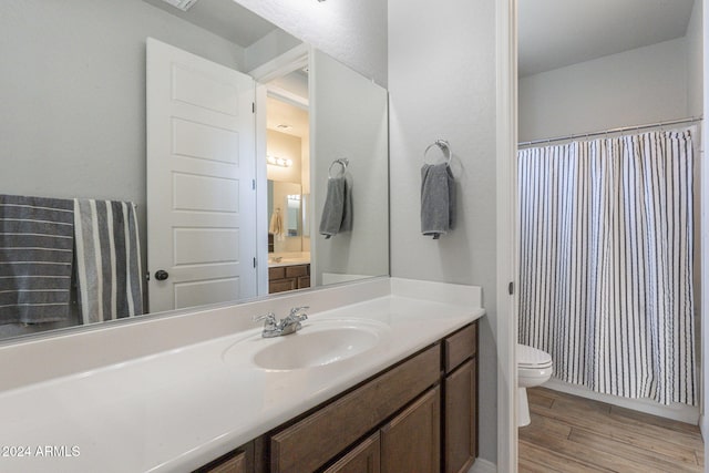 bathroom with hardwood / wood-style flooring, vanity, and toilet