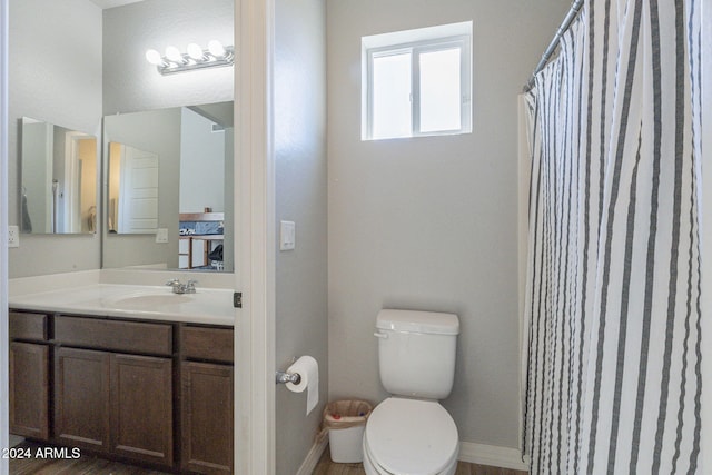 bathroom with a shower with curtain, hardwood / wood-style flooring, vanity, and toilet