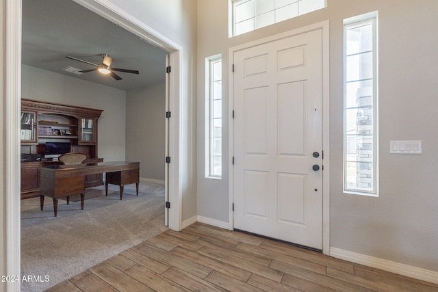 foyer entrance with ceiling fan, plenty of natural light, and light wood-type flooring