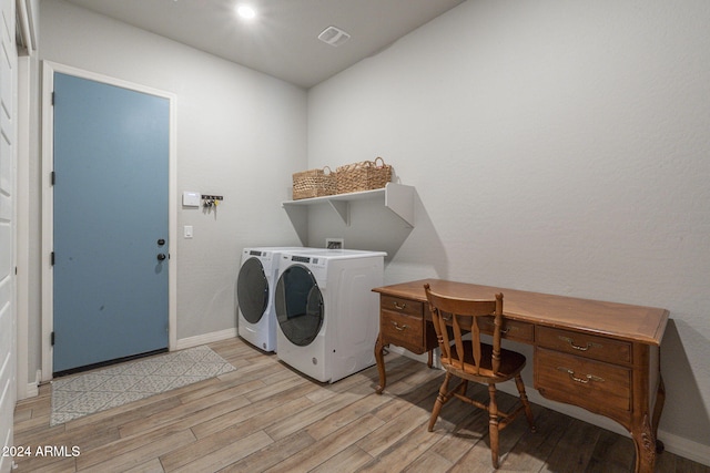 washroom with light hardwood / wood-style floors and washer and clothes dryer