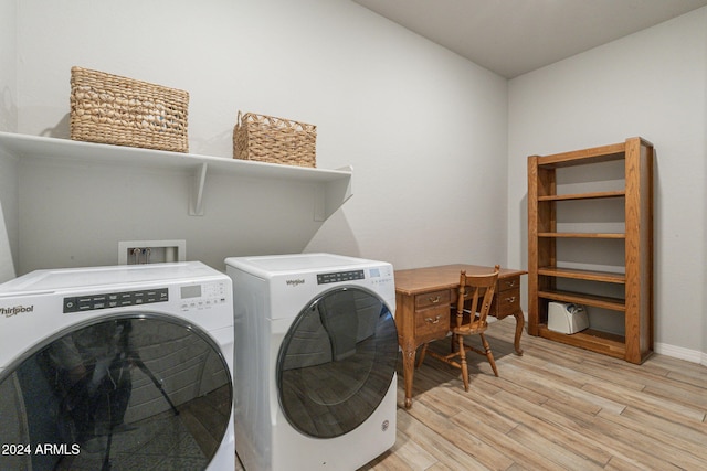 laundry room featuring washing machine and clothes dryer and light hardwood / wood-style floors