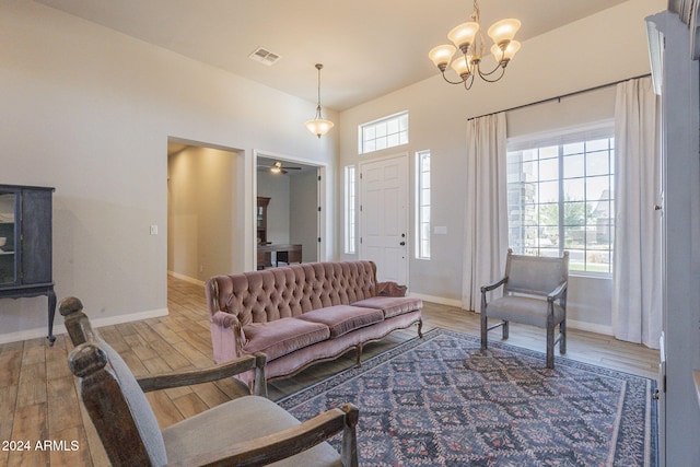 living room featuring hardwood / wood-style floors, a healthy amount of sunlight, and ceiling fan with notable chandelier