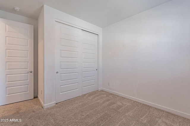 unfurnished bedroom featuring carpet flooring and a closet