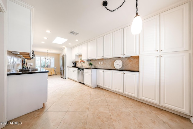 kitchen featuring stainless steel appliances, dark countertops, light tile patterned floors, tasteful backsplash, and white cabinets