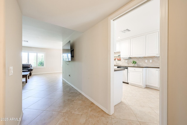 corridor featuring light tile patterned flooring and baseboards