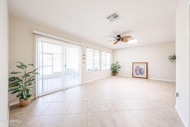 spare room featuring ceiling fan, light tile patterned floors, and baseboards