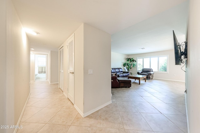 corridor with light tile patterned floors and baseboards