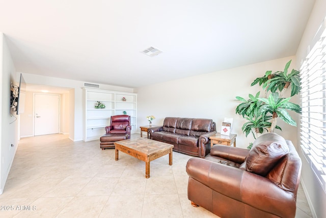 living room with healthy amount of natural light, light tile patterned floors, and baseboards