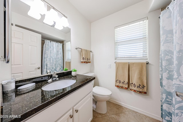 bathroom with tile patterned flooring, healthy amount of natural light, vanity, and toilet