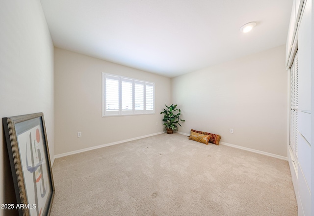 carpeted spare room featuring baseboards