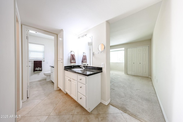 bathroom featuring toilet, vanity, tile patterned floors, and baseboards