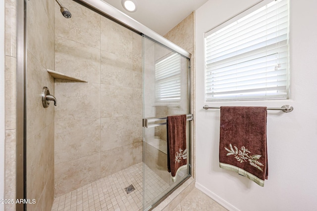 full bathroom featuring a shower stall and tile patterned flooring