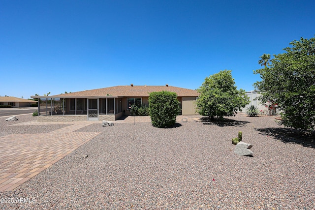 rear view of house featuring a sunroom and fence