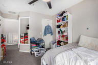 bedroom with dark colored carpet and ceiling fan