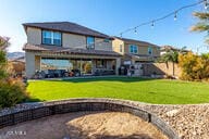 back of property with a lawn and a patio