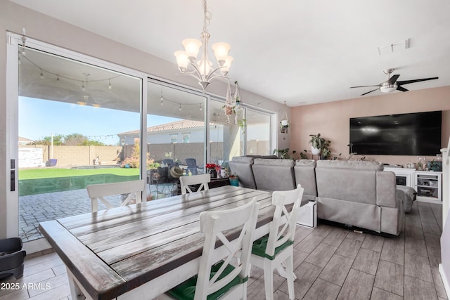 dining area featuring ceiling fan with notable chandelier