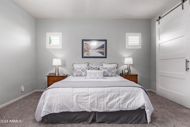 bedroom featuring a barn door and carpet floors