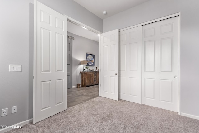 unfurnished bedroom featuring light colored carpet and a closet